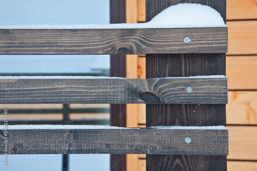 Wooden fence of a private house. Background in snowy weather. Wooden fence of a private house. Background in snowy weather.