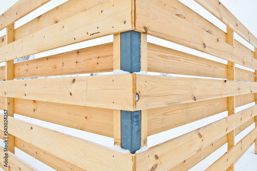 Wooden fence of a private house. Background in snowy weather. Wooden fence of a private house. Background in snowy weather.