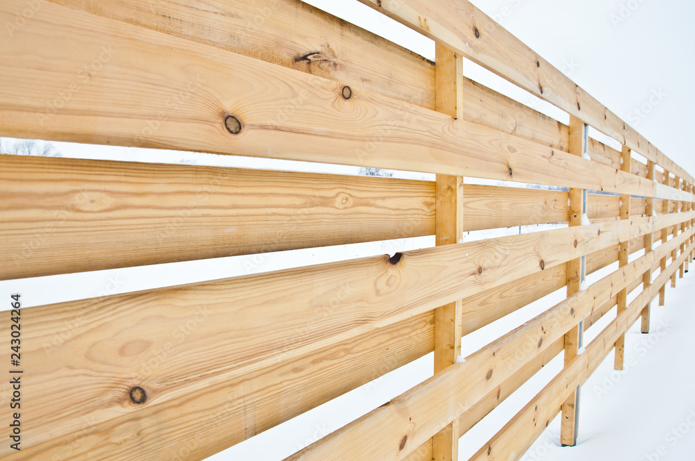 Wooden fence of a private house. Background in snowy weather. Wooden fence of a private house. Background in snowy weather.