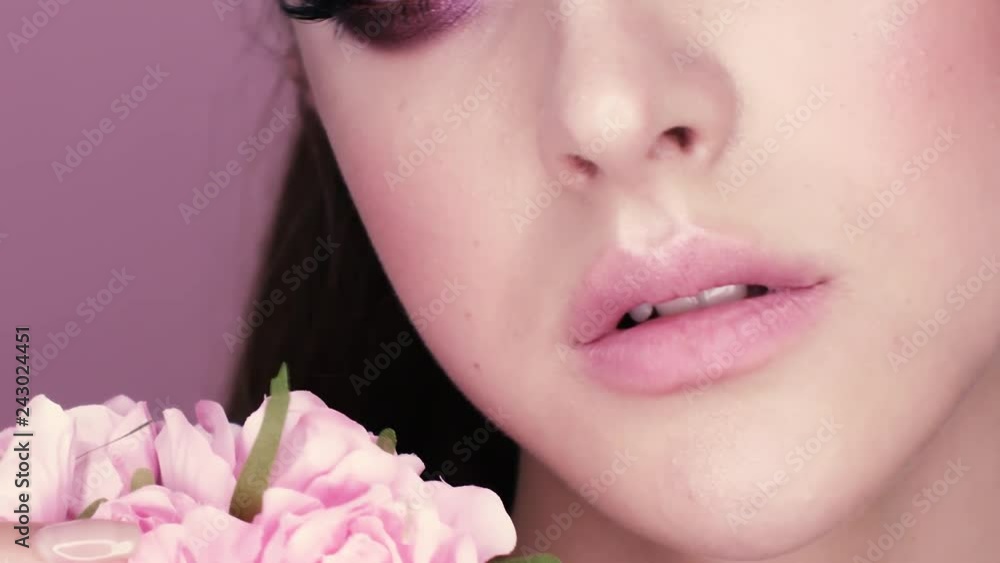 beauty portrait of a beautiful girl with makeup and flowers. closeup shot in studio on a pink background beauty portrait of a beautiful girl with makeup and flowers. closeup shot in studio on a pink background