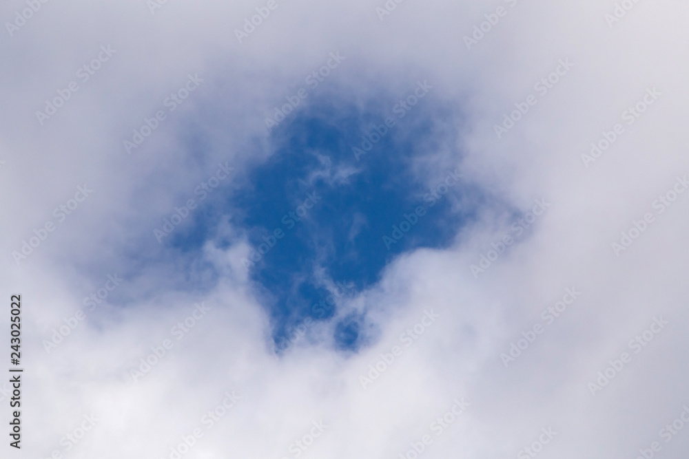 Obraz premium view on blue sky through hole in cloud