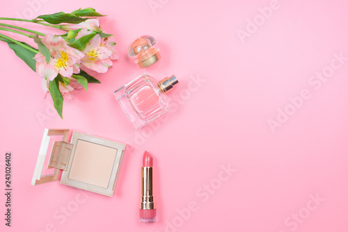 Cosmetics and flowers on a pink background. Beauty concept.