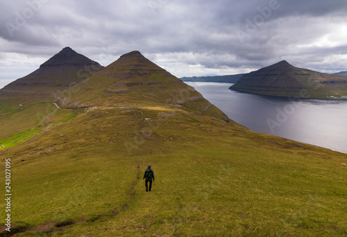 Person walking on the trail in the mountain above Klaksvik, Faroe Islands. Mt. Klakkur and viewingpoint