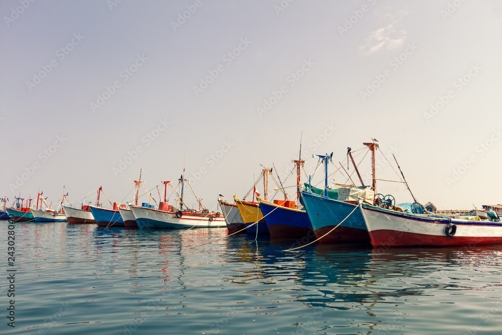 Colorful fishing boats anchored at the pier of Paracas, Peru