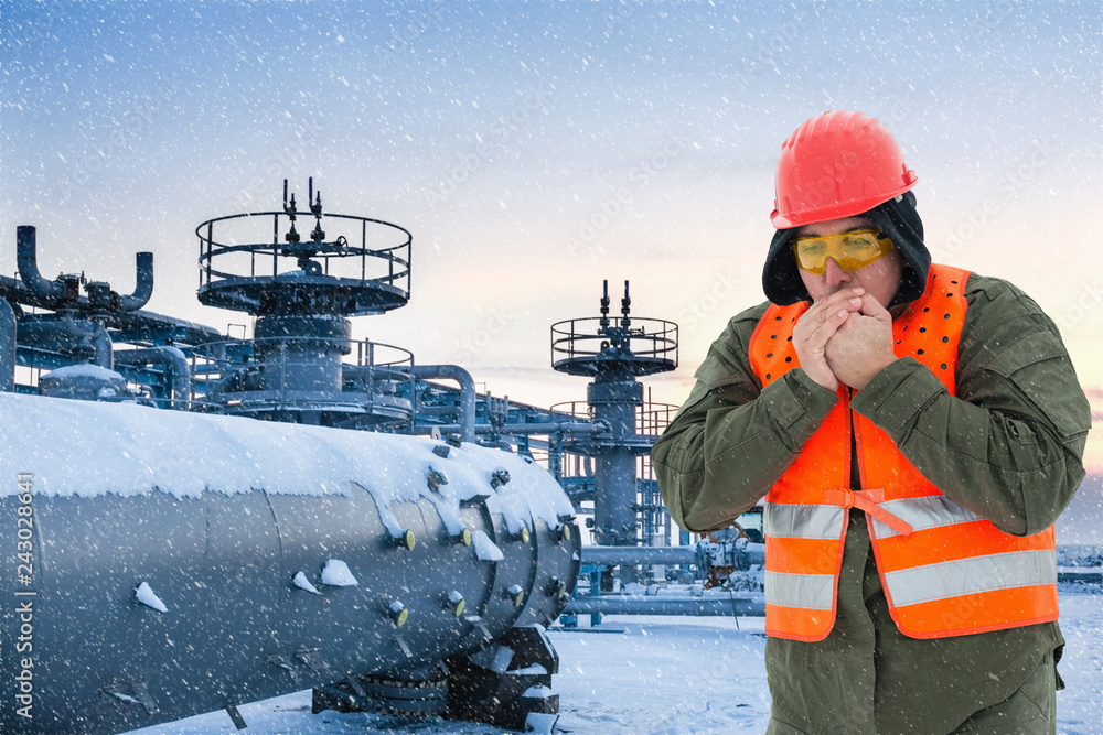 Ταπετσαρία Worker at the cold oil field , natural gas storage in the background