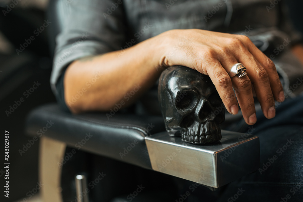Retro style man sit on the chair and hold skull with scissors. - Image Retro style man sit on the chair and hold skull with scissors. - Image