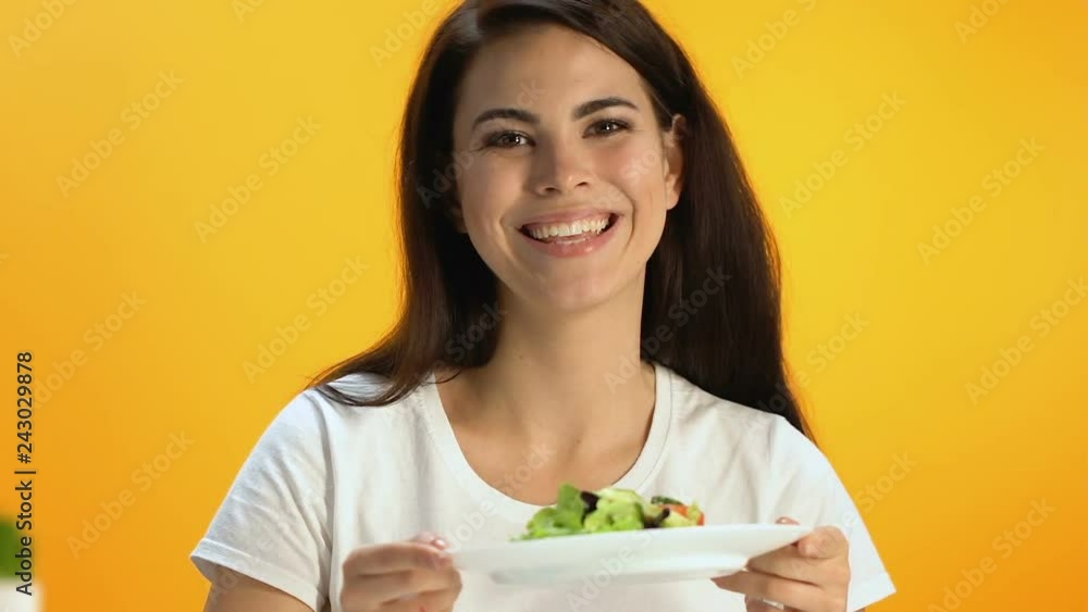 Cute brunette holding plate with fresh vitaminized salad and smiling, diet Cute brunette holding plate with fresh vitaminized salad and smiling, diet