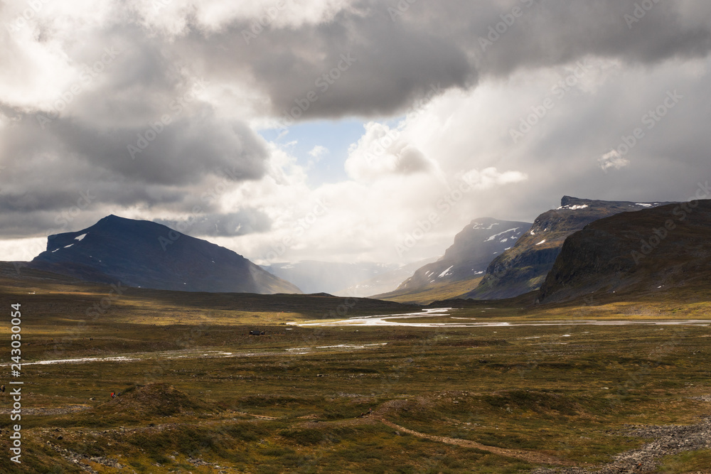 Valley with mountains in the distance and water flowing through a river during the hike of Kungsleden (Kings path) in northern Sweden.