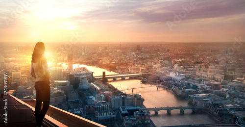 Photography Young woman looking at the City of London at sunset