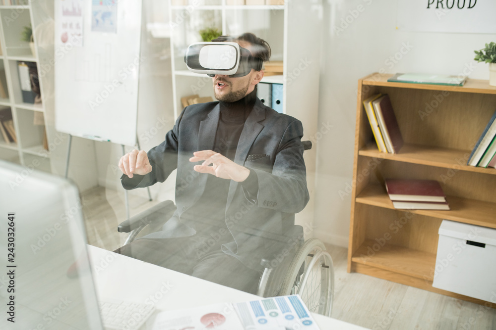 Obraz premium Disabled businessman using virtual reality device at the table at office