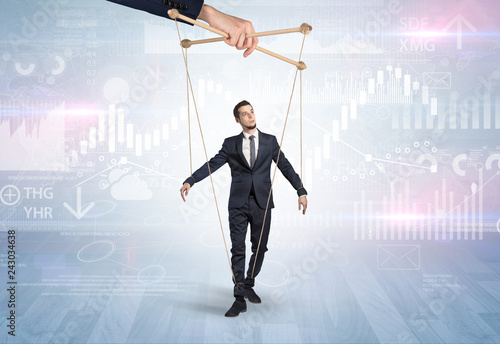 Fotografía Puppet businessman controlled by another hand with financial concept