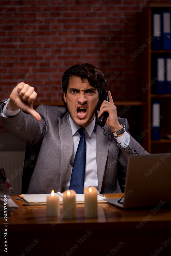 Businessman working late in office with candle light Businessman working late in office with candle light