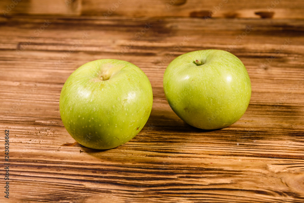 Two ripe green apples on a wooden table Two ripe green apples on a wooden table