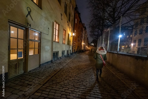 Frau alleine nachts in der Altstadt von Gamla Stan, Stockholm, Schweden