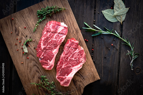 Tableau sur toile Raw chuck roll steaks premium beef with seasonings on wooden board, top view, ru