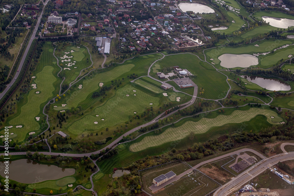 view from the window of the aircraft on the fields, forests, houses, ponds