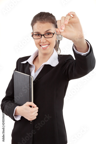 Young beautiful businesswoman real estate agent holding and showing home key