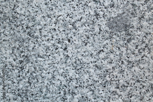 Polished granite wall, in black and white colors. Outdoor photo taken with daylight