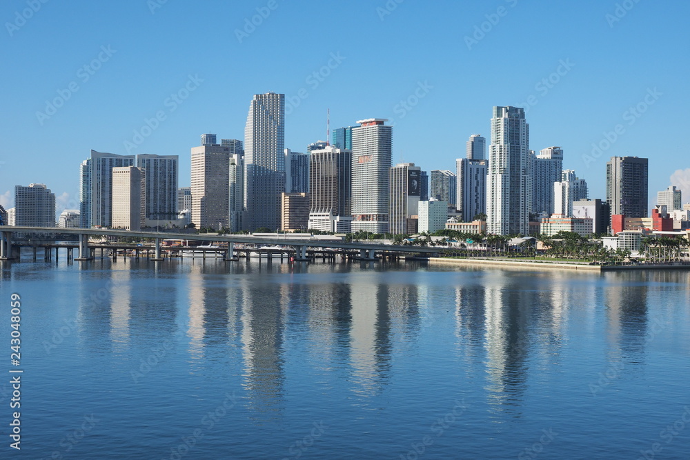 Miami, Florida 09-15-2018 The City of Miami skyline and its reflection on a very calm Biscayne Bay in morning light.