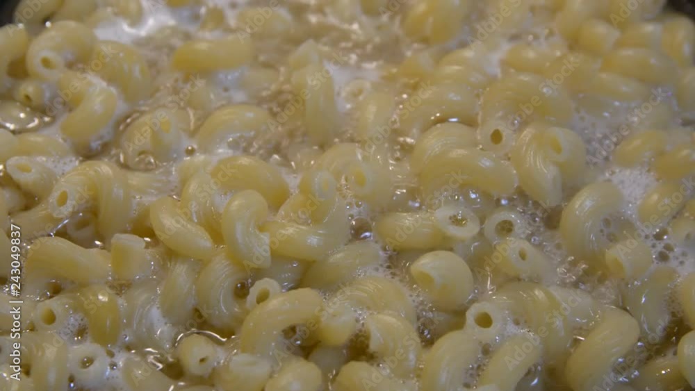 Pasta is cooked in a black cauldron close up, home made, Pasta cooked in a boiling pot on the stove close-up Pasta is cooked in a black cauldron close up, home made, Pasta cooked in a boiling pot on the stove close-up