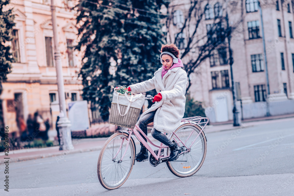 Pretty stylish female person riding her bicycle