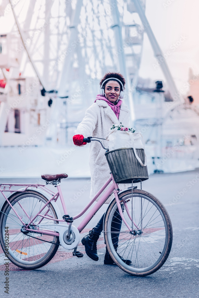 Fototapeta premium Enigmatical girl standing near her eco transport