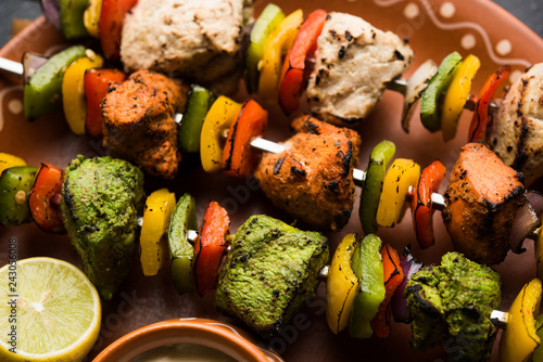 Chicken Hariyali kakab or Malai malai kebab served with skewers and yogurt dip in a plate. selective focus photo