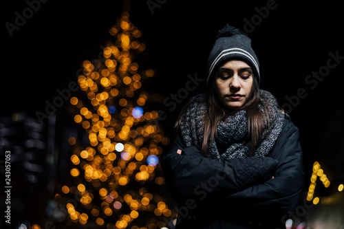 Night portrait of a sad woman feeling alone and depressed in winter.Winter depression and loneliness concept