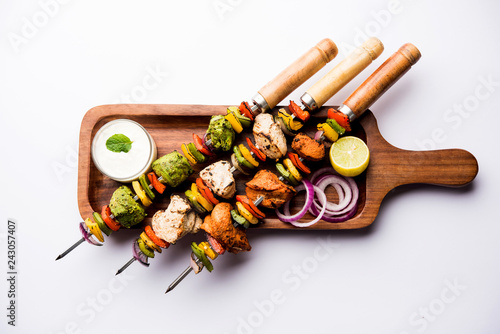 Chicken Hariyali kakab or Malai malai kebab served with skewers and yogurt dip in a plate. selective focus photo