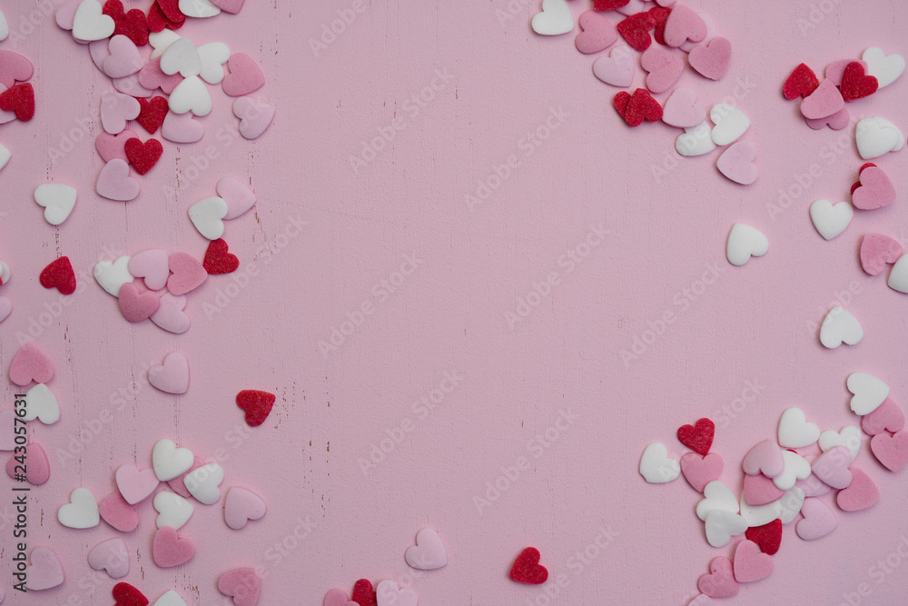 Flat lay with hundreds of tiny heart-shaped sugar sprinkles with space for copy text or love letter message as gift of symbol for affection and romantic feelings for Valentine's Day on February 14th