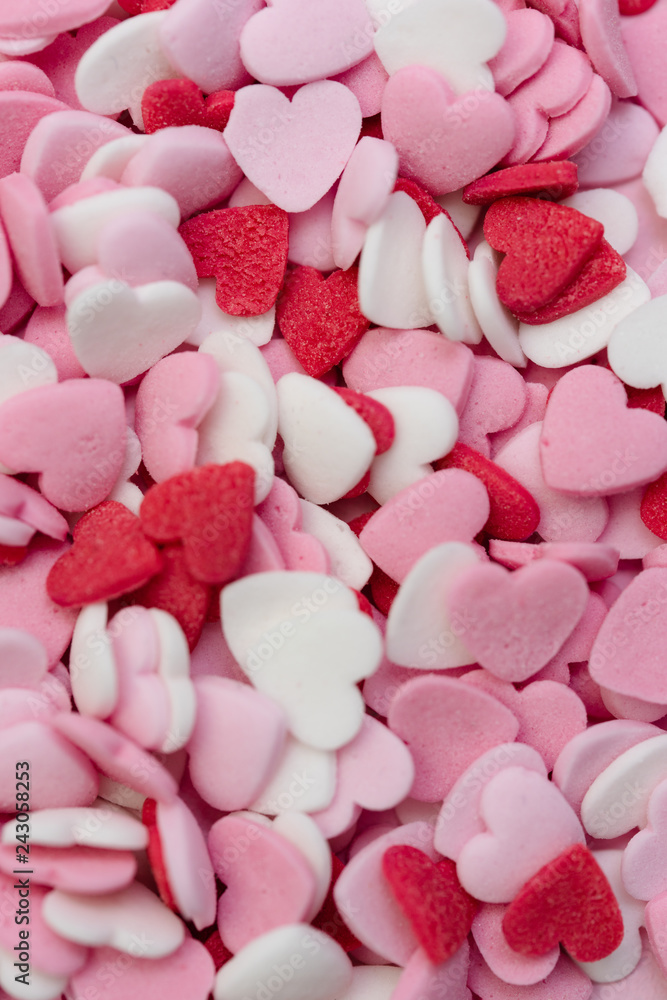 Close up macro shot of hundreds of small heart-shaped sugar sprinkles in red, pink and white for Valentine's day card, symbol for love, emotion or romantic feelings as background or wallpaper image Close up macro shot of hundreds of small heart-shaped sugar sprinkles in red, pink and white for Valentine's day card, symbol for love, emotion or romantic feelings as background or wallpaper image