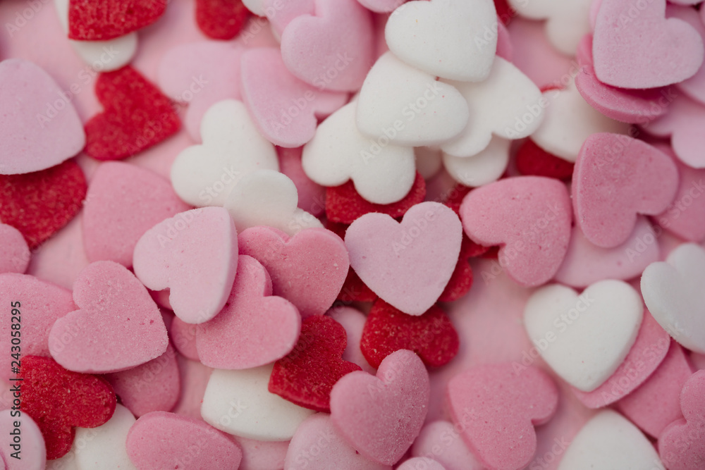 Close up flatlay shot of hundreds of small heart-shaped sugar sprinkles in red, pink and white for Valentine's day card, symbol for love, emotion or romantic feelings as background or wallpaper image Close up flatlay shot of hundreds of small heart-shaped sugar sprinkles in red, pink and white for Valentine's day card, symbol for love, emotion or romantic feelings as background or wallpaper image