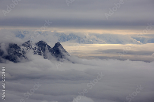 Abstract landscape photograph, mountains shrouded in clouds. Fog floating between mountain peaks, Chinese mountains. Ridgeline, artistic minimalistic landscape image. peaceful nature background image © Cedar