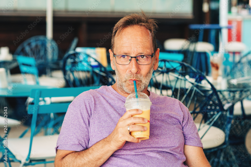 Summer outdoor portrait of happy man holding milkshake Summer outdoor portrait of happy man holding milkshake