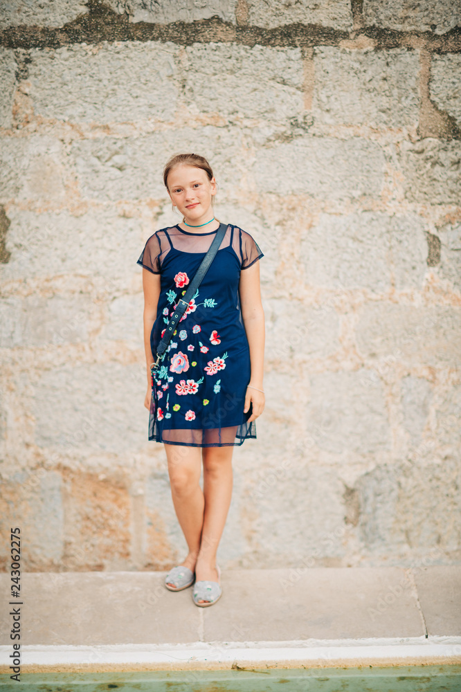 Outdoor fashion portrait of beautiful young girk wearing blue fashionable dress Outdoor fashion portrait of beautiful young girk wearing blue fashionable dress