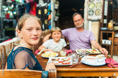Happy family with children in outdoor restaurant during summer vacation in Spain