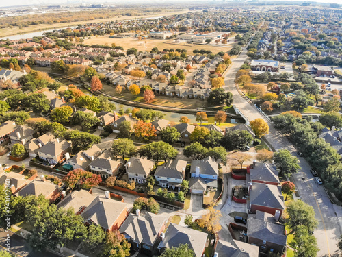 Aerial view riverside residential subdivision in fall season with colorful autumn leaves near Dallas, Texas. Urban sprawl of residential houses and apartment building complex