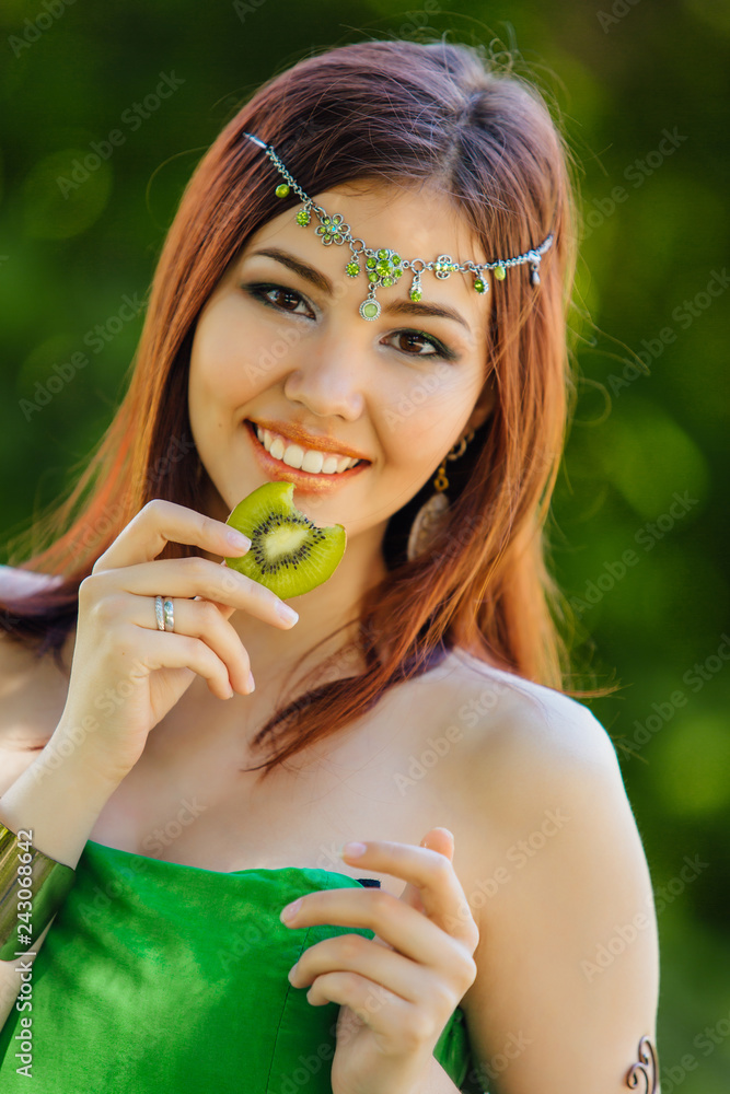 Beautiful young asian woman with slice of kiwi Beautiful young asian woman with slice of kiwi