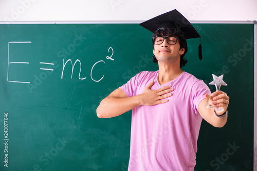 Foto Young male physic standing in front of the green board