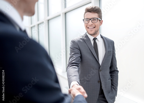 Manager greets the client with a handshake.