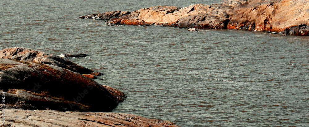 cliffs with red rocks at the finish bay near helsinki, finland