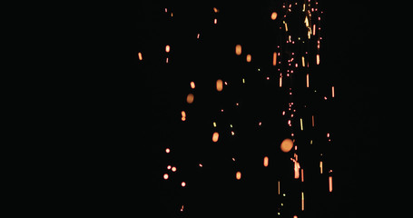 hot sparks slowly falling from above black background
