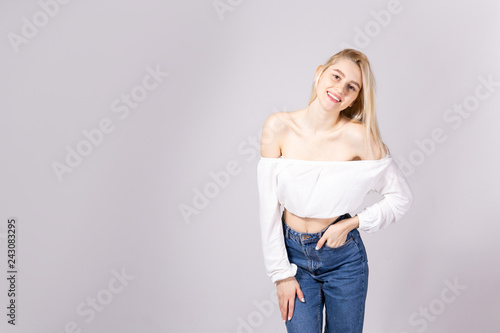 Foto Studio shot of gorgeous young blonde woman with straight hair wearing off shoulder crop top sweater and high waisted denim shorts