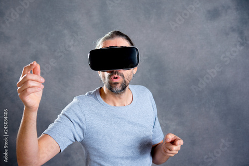 man using virtual reality glasses and looking surprised