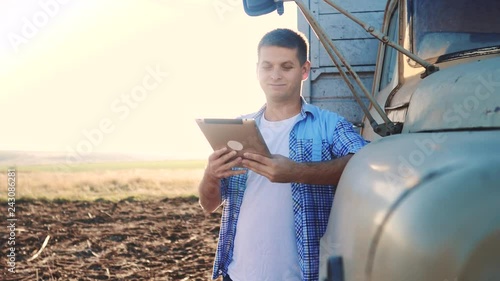 smart farming driver . man farmer driver stands with a digital tablet near the truck. slow motion video. Portrait businessman farmer standing in the field harvesting lifestyle season car. driver photo