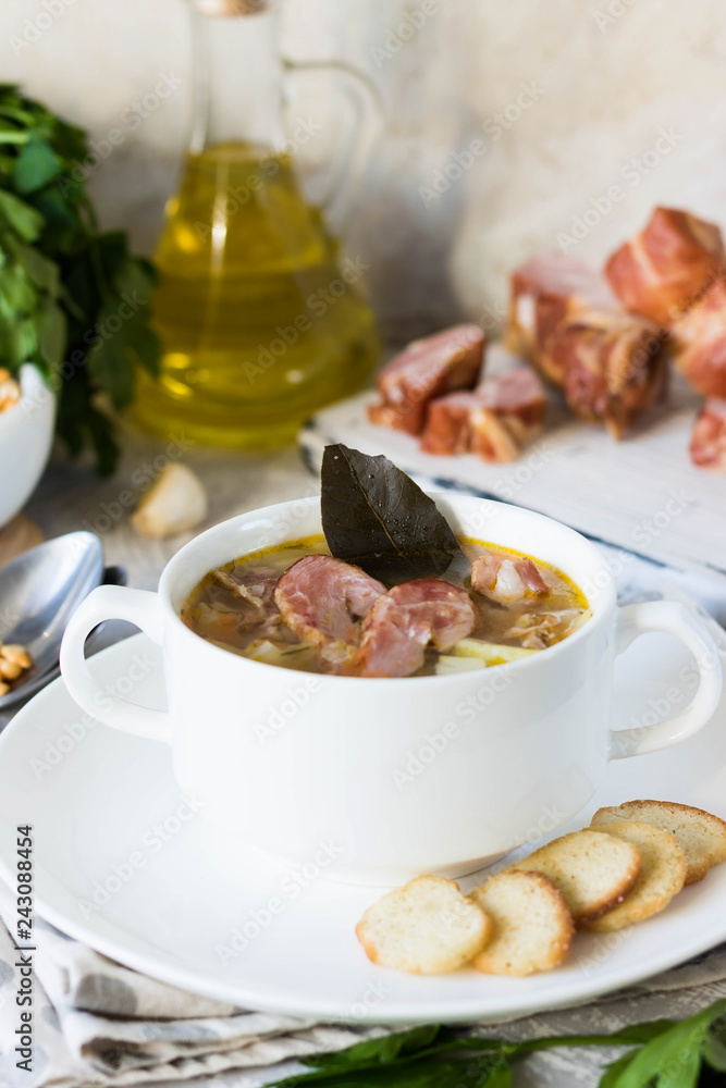 Thick pea soup with smoked meats in a white plate