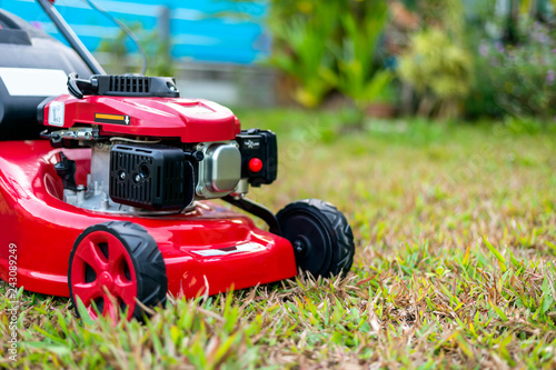 close up lawn mower in the park on the grass. over light [blur and select focus background