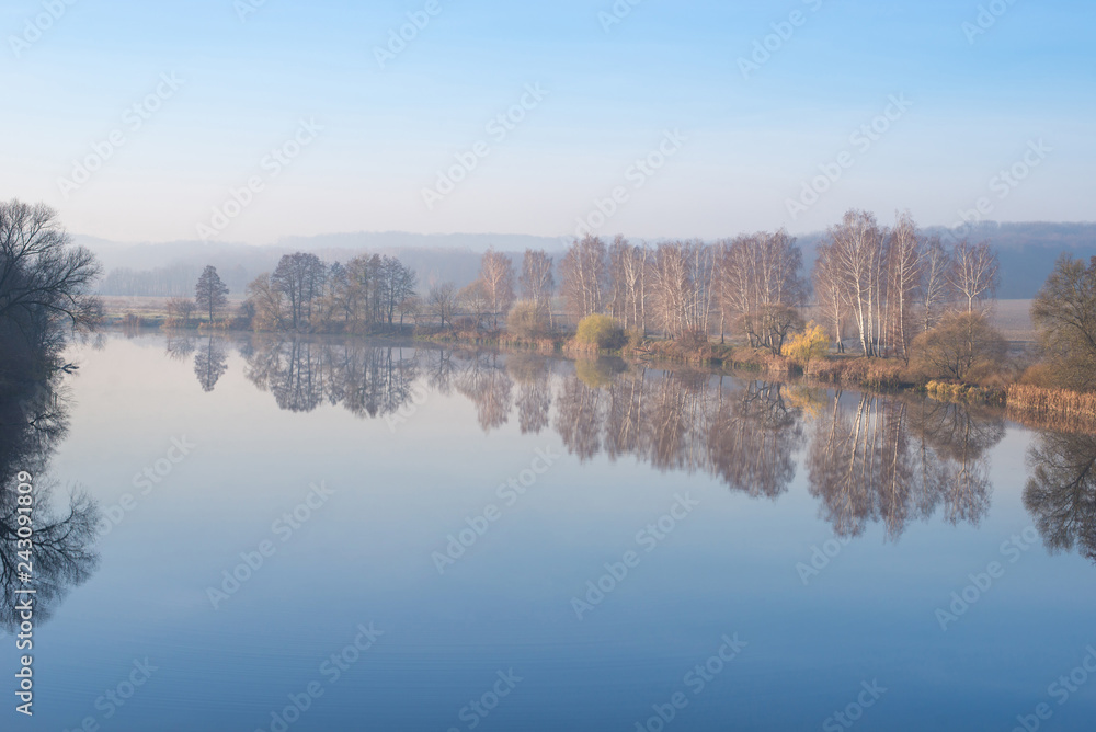 Autumn landscape. Reflection of trees in a river
