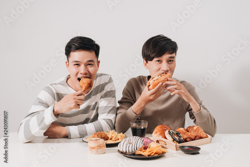 Wallpaper Mural Two friends eating burgers. french fries, having fun and smiling Torontodigital.ca