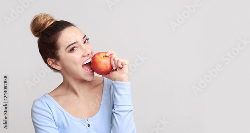 Fotografie Healthy eating. Pretty girl biting fresh apple